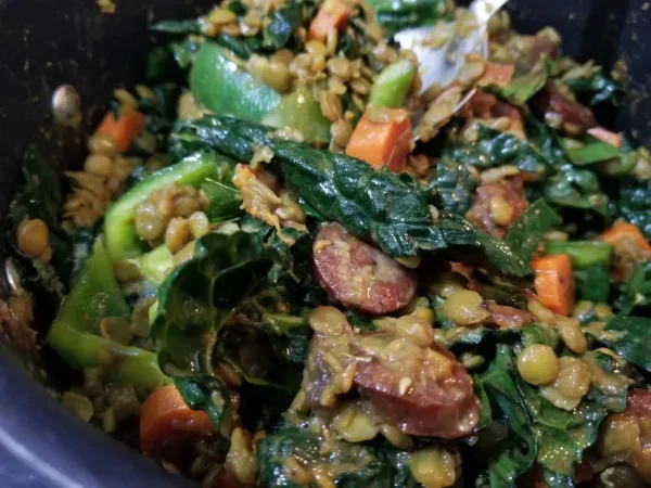 cooked lentil stew with sausage and vegetables in a pot