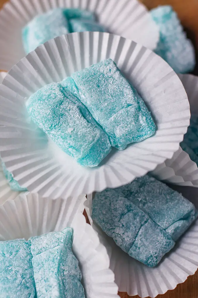 mint green soft candies with powdered sugar on cupcake liners