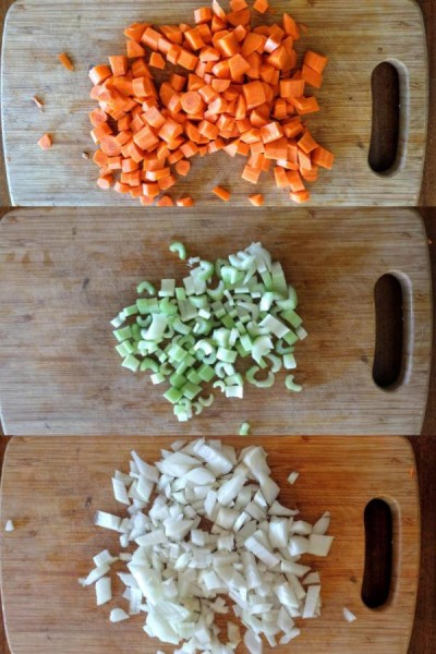 chopped carrots, celery, and onion on a cutting board.