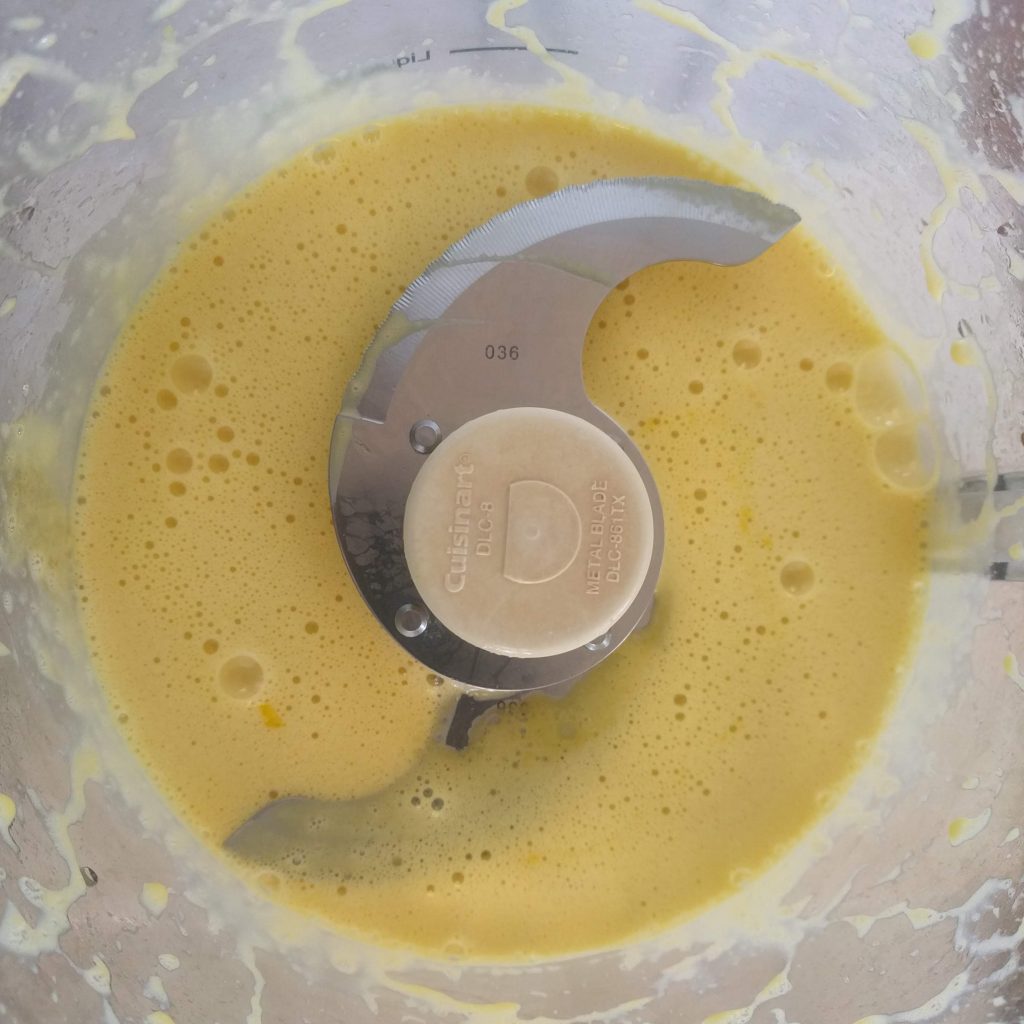 Food processor bowl with mayonnaise ingredients after first blend.
