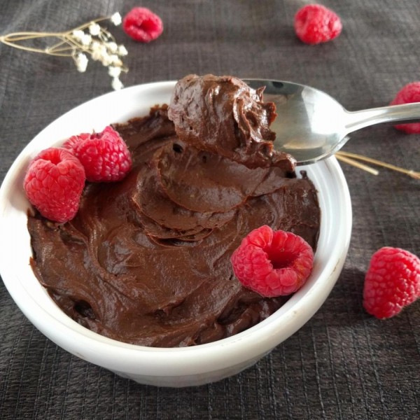Chocolate pudding in white ramekin with raspberries