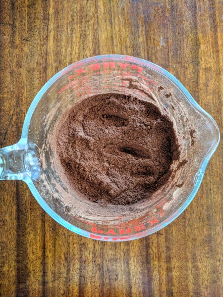 Paleo brownie dry ingredients mixed in measuring cup.