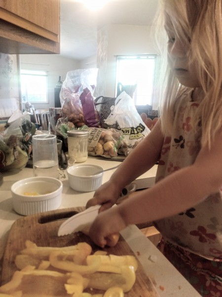 Kid chopping peppers with plastic knife