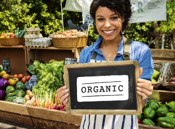 Woman holding organic sign at farmer's market