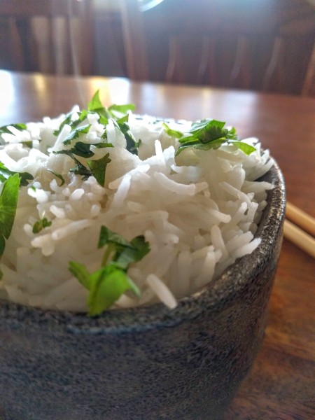 cooked rice in bowl, garnished with cilantro