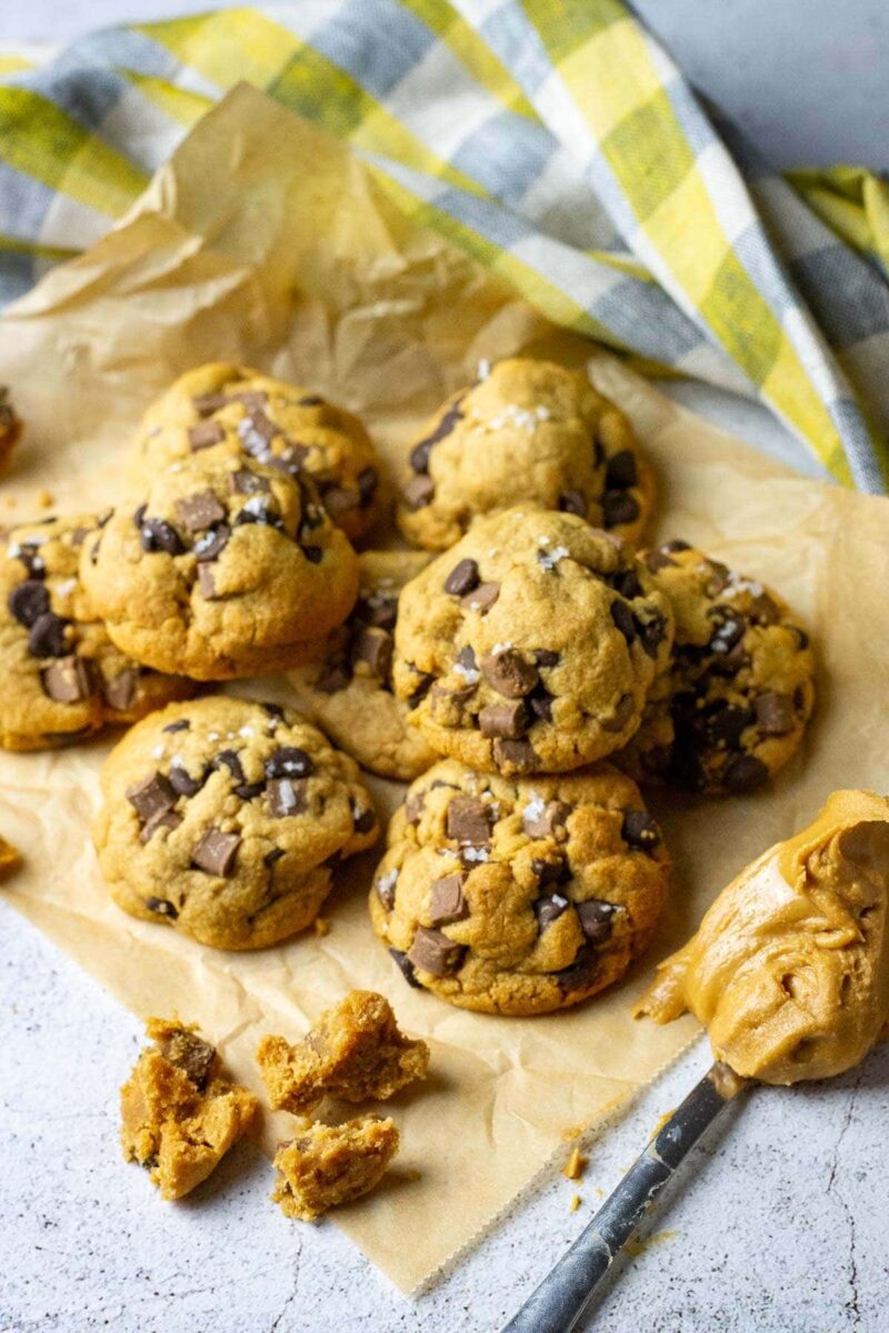 G;uten free peanut butter cookies with chocolate chips and sea salt flakes on a brown parchment paper