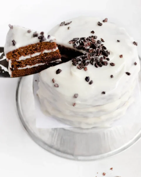 3 layers of almond flour cake filled and covered with cream cheese frosting topped with chocolates