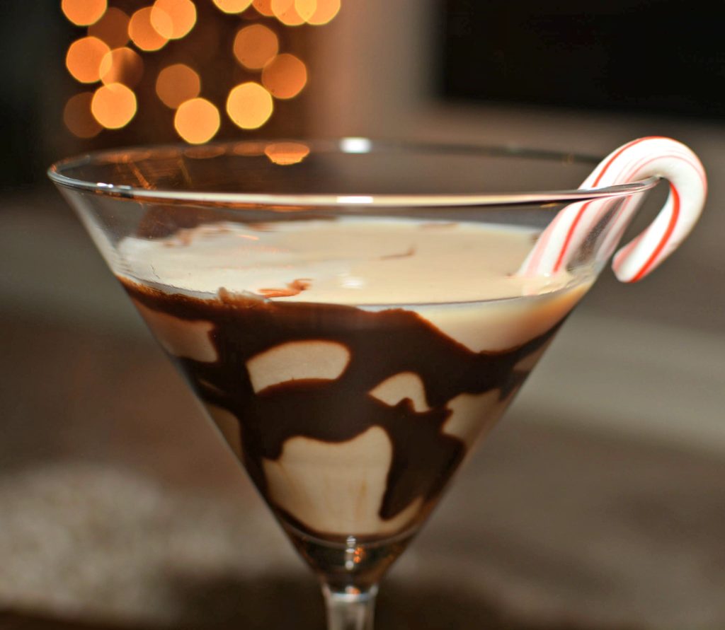 brown and milksihh colored drink with candy cane in a  martini glass