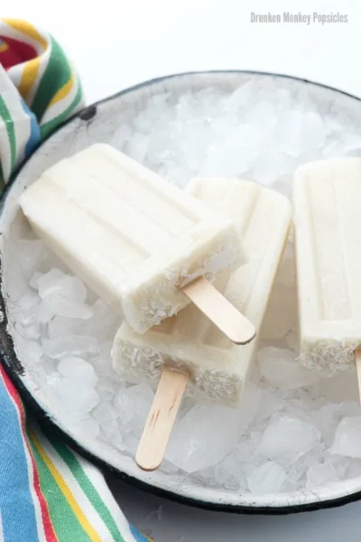 drunken coconut banana popsicles served on ices