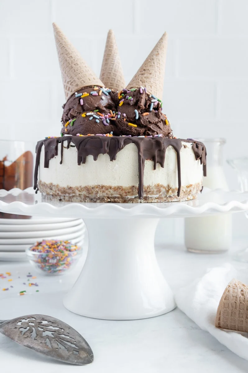 a beautiful designed ice cream cake with chocolate and ice cream cones on top