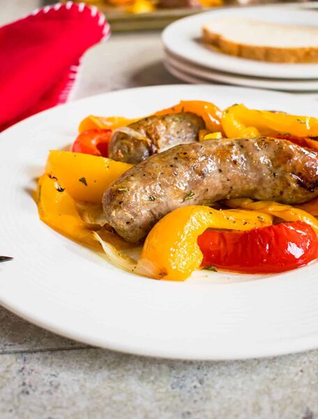 Baked Sausages, Peppers and Onions on a white plate