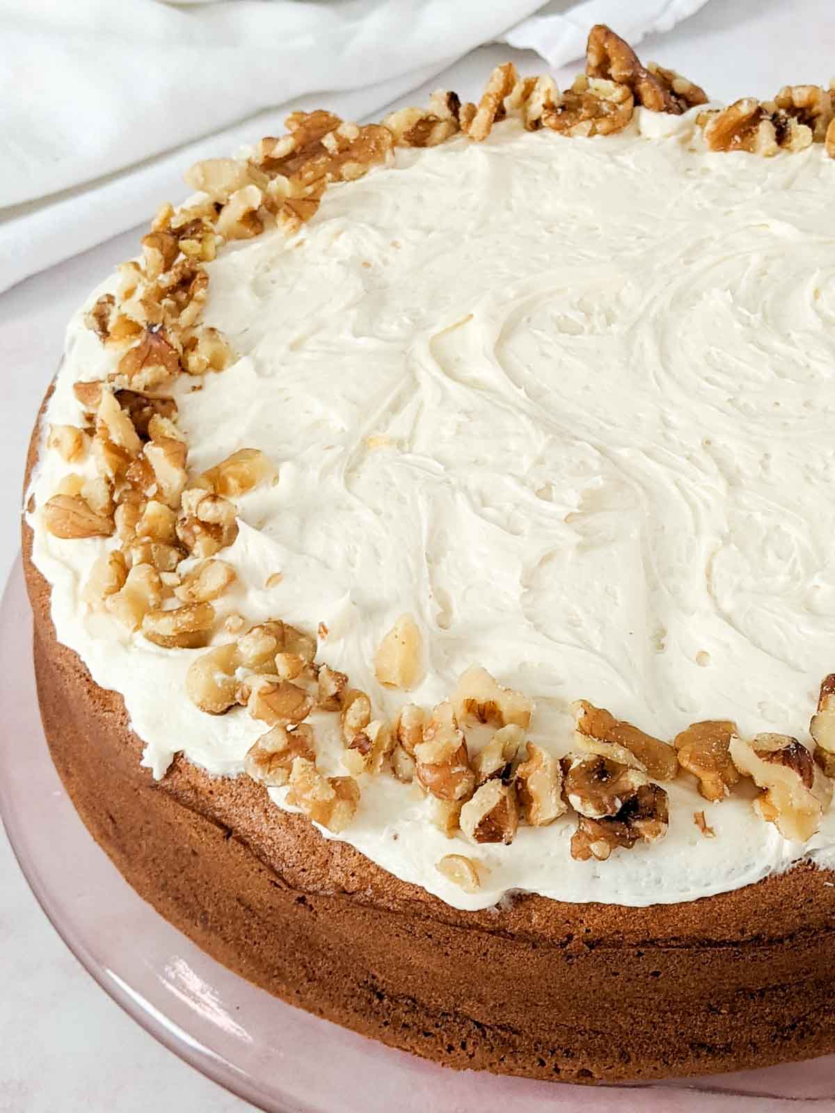 gluten and dairy free banana cake topped with buttercream frosting and walnuts
