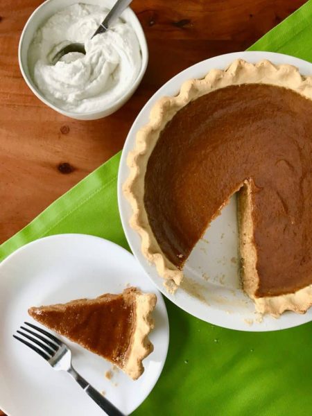 Pumpkin pie with slice on a plate