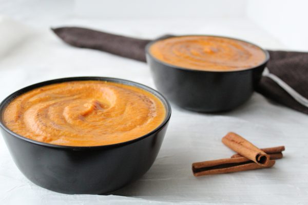 Coconut carrot ginger soup - two bowls with cinnamon sticks