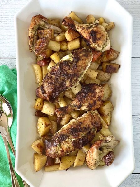 Roasted Chicken with Potatoes and Carrots with pesto on a whitte serving dish