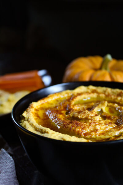 pumpkin hummus with pumpkin and serving tray in background