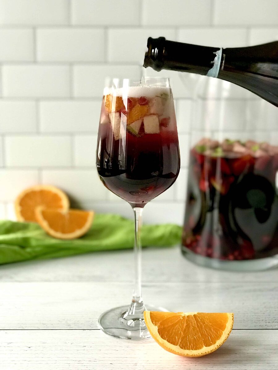 Sparkling winter red sangria  in a wine glass with slices of oranges
