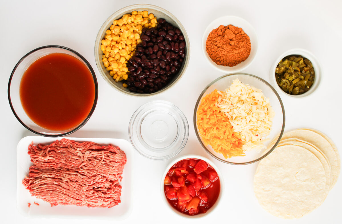 Ingredients for beef enchilada casserole in seperate small bowls.