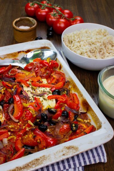 baked feta with veggies and olives in a white oven dish
