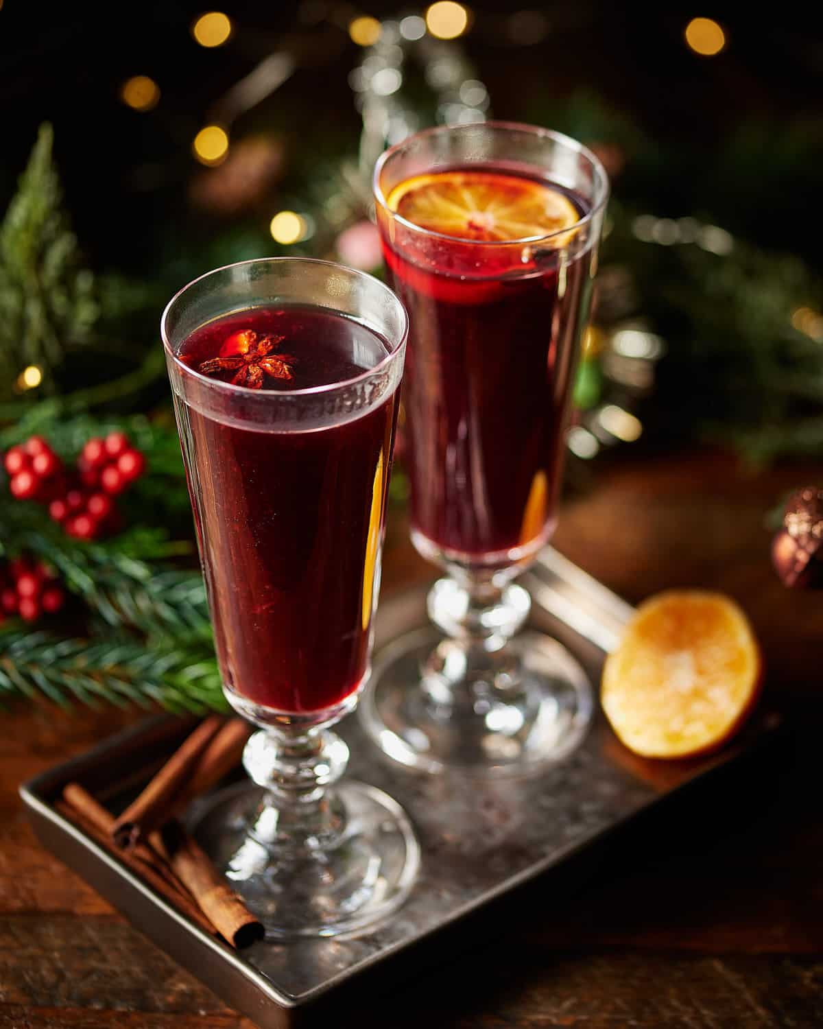 2 mulled red wines with orange slices and star anise, Christmas decor on the background