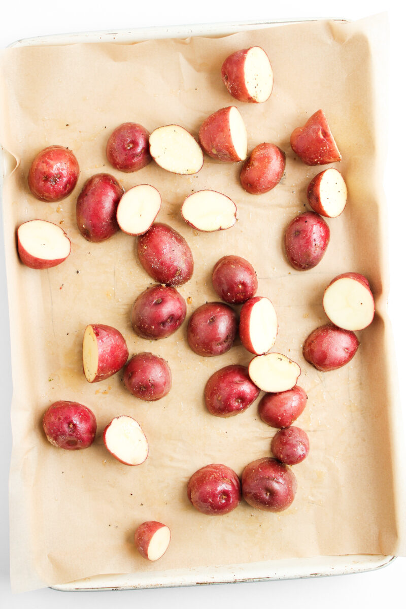 Potatoes on sheet pan with brown parchment paper.