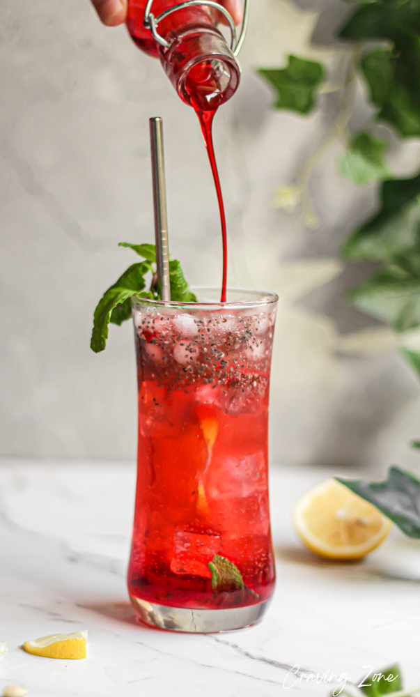 Rose lemonade with mint leaves, rose syrup and lemon on a white table top counter