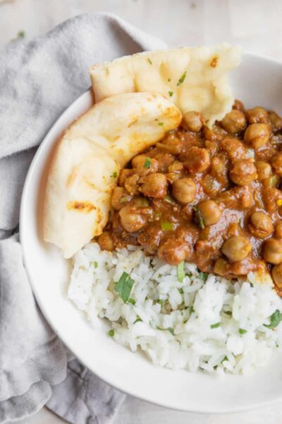 الحمص المطبوخ في صلصة الطماطم البهارات تقدم مع الأرز في وعاء أبيض