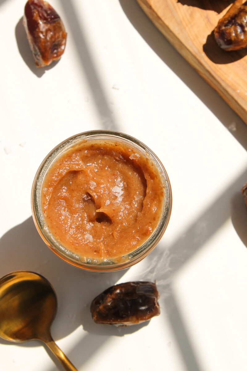 Overhead of date caramel in clear jar.