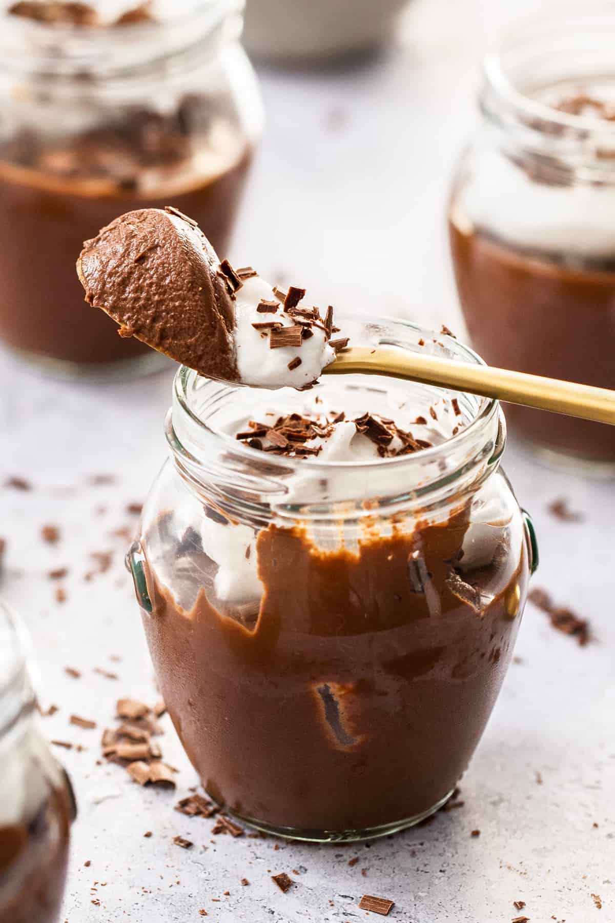 spoonful of chocolate mouse with chocolate shavings in jar glasses