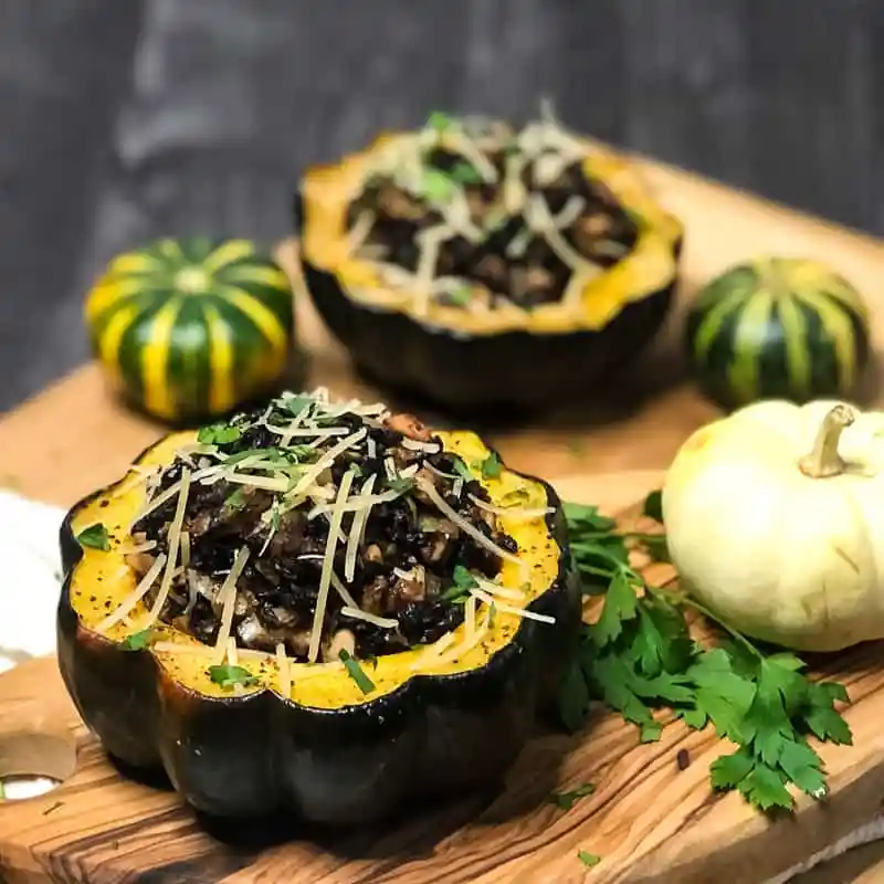 cooked acorn stuffed with black rice, almonds, onions, garlic, mushroom, herbs and spices