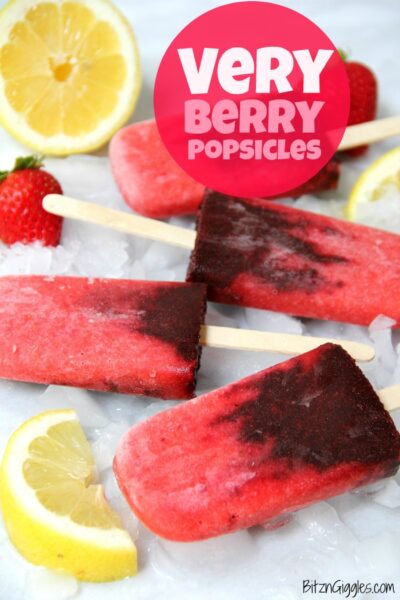 dairy free berries popsicles  over ice cubes and with fresh strawberries, blackberries and lemon slices 