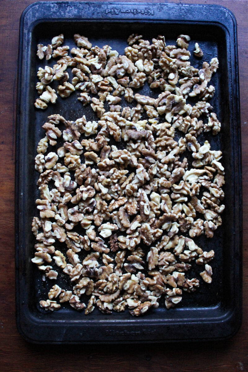 Walnuts spread out on a baking sheet.