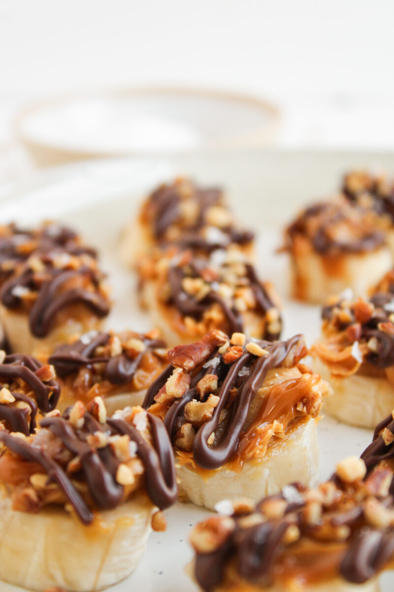 One banana snickers bite focused with others blurred around it on a plate.