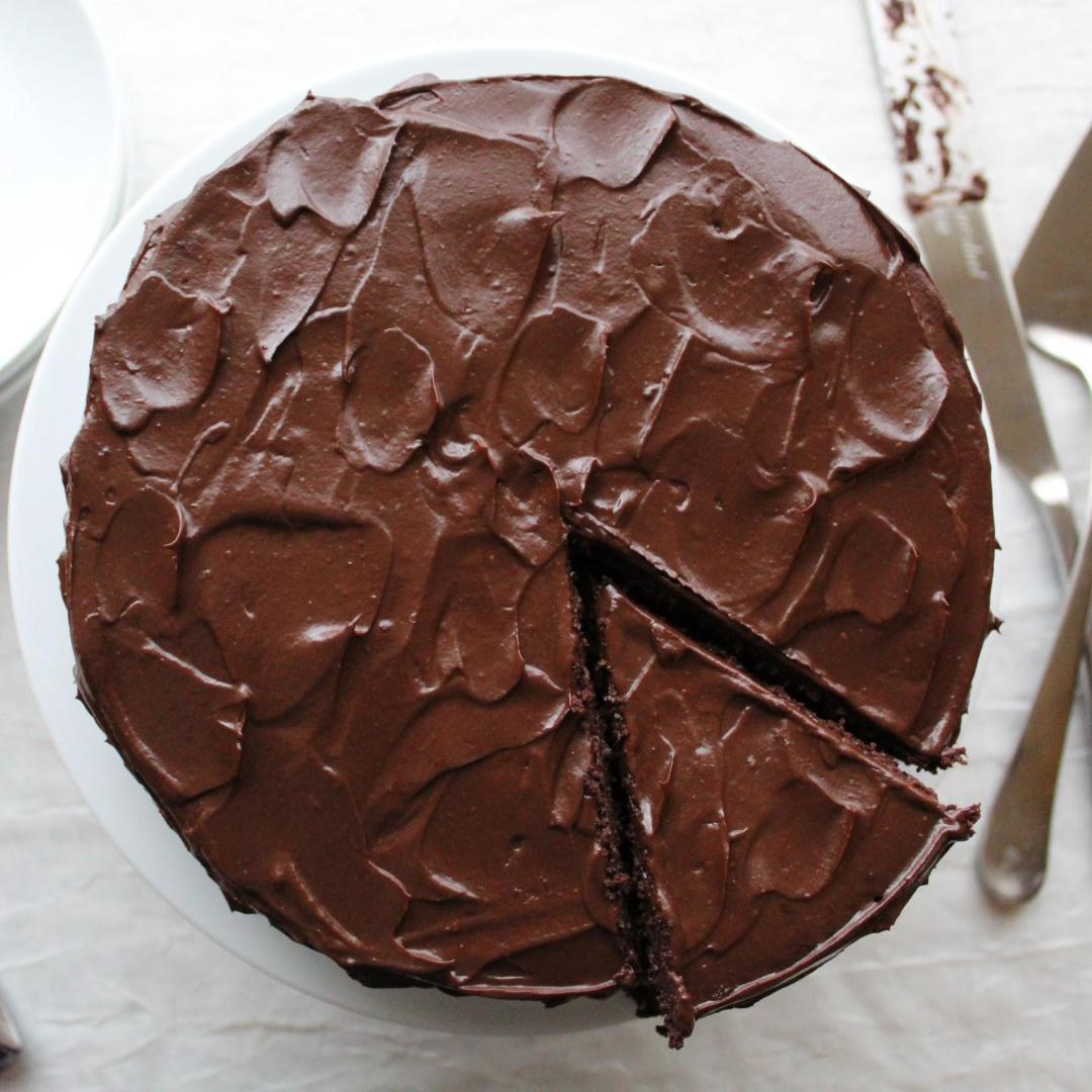 frosted chocolate cake with chocolate frosting with slice cut out