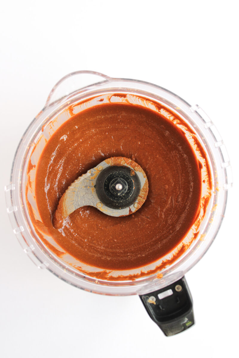 Chocolate peanut butter in food processor on white background.