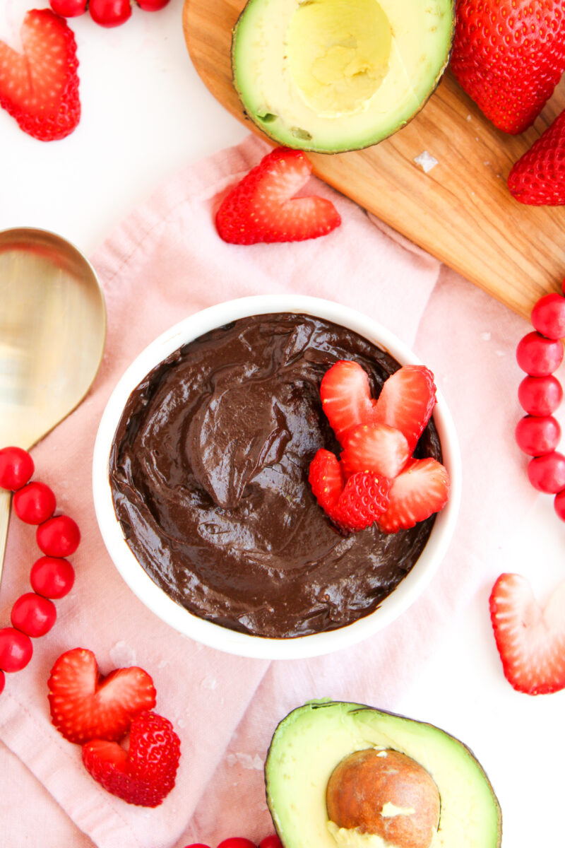 Overhead of chocolate pudding in a white bowl with strawberries.