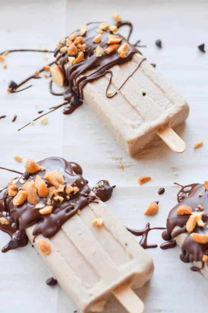 Chocolate Peanut Butter Banana Popsicles- top half  of each popsicle drizzled  with chocolate with crushed peanuts on top