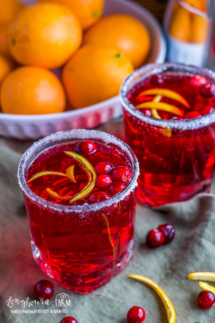 Christmas punch in small glasses rimmed with white sugar with cranberries and slices of orange peels