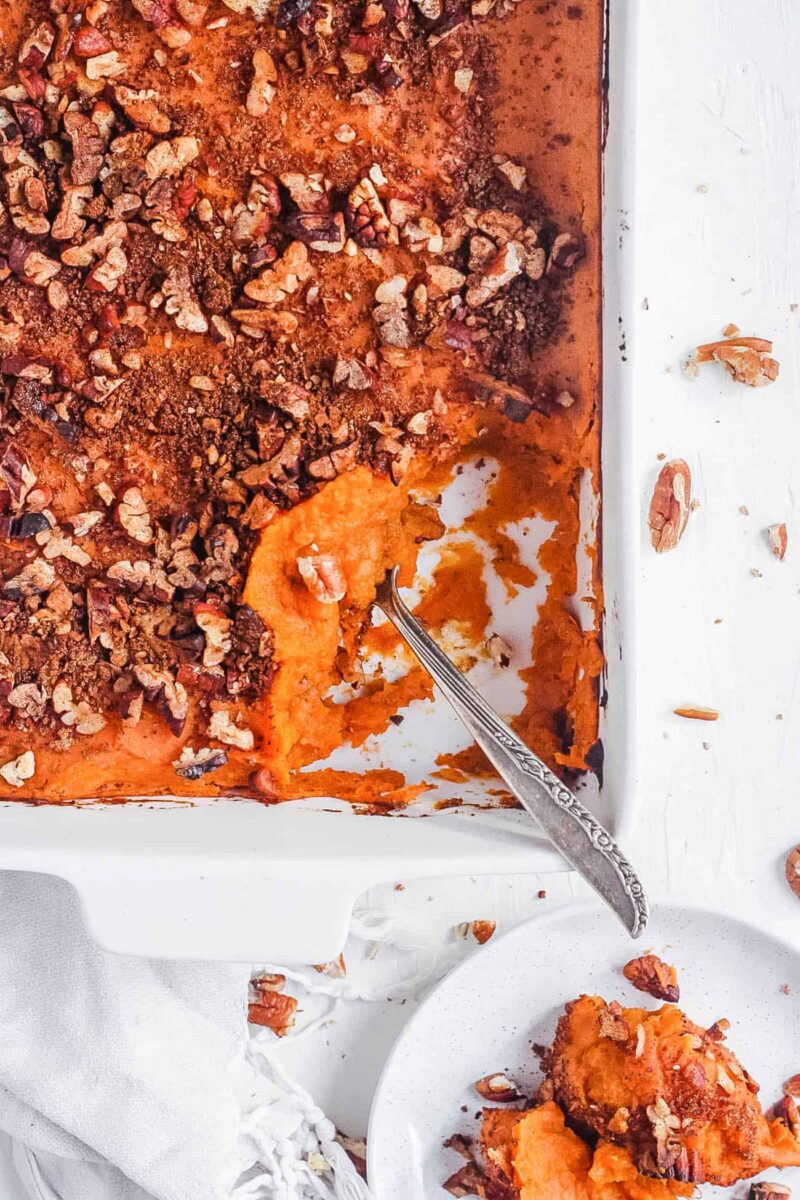 sweet potato casserole with chocolate and nuts in a baking dish with a spoon