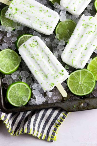 coconut liime popsicles with ice cubes and slices of limes