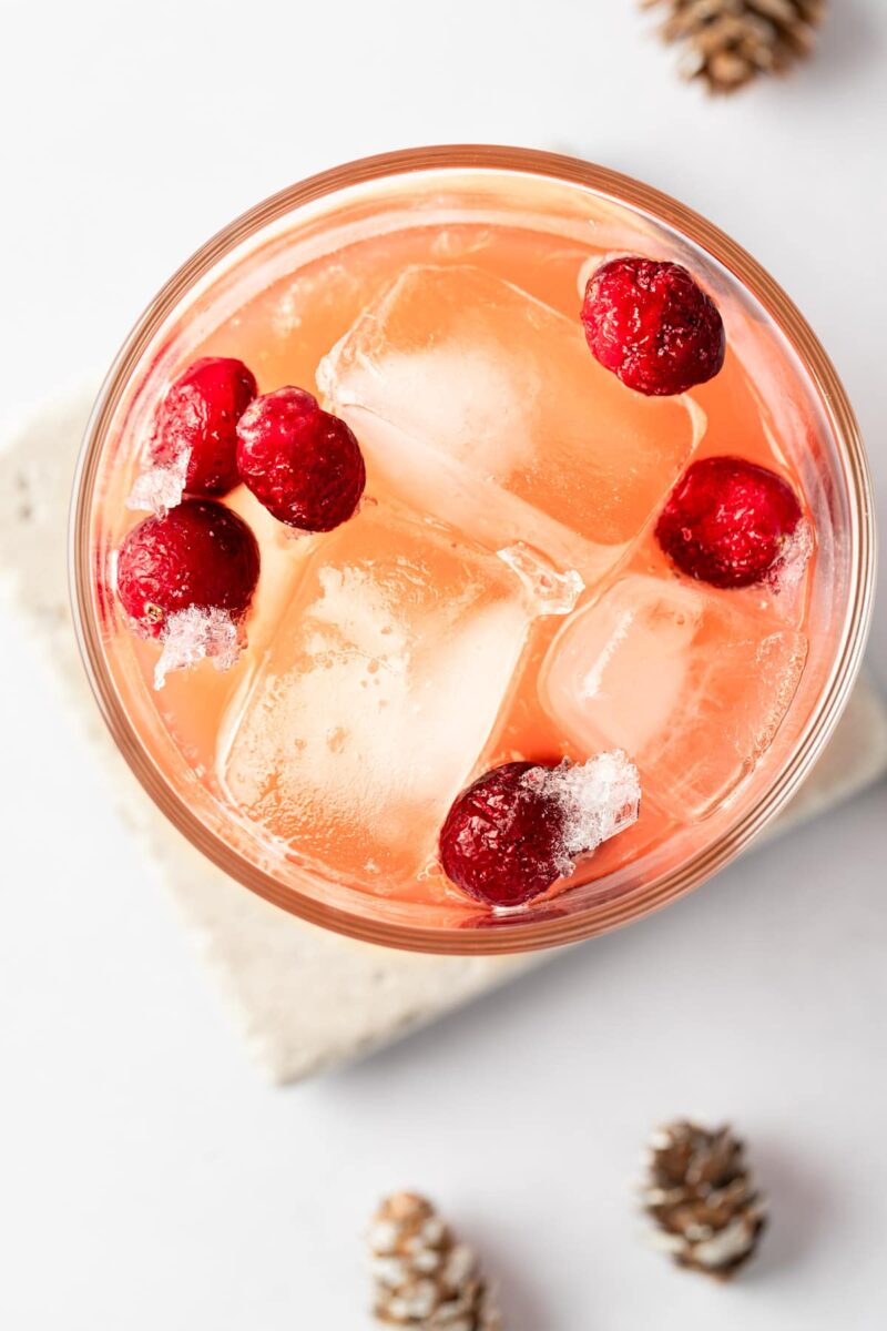 air shot close-up image of cranberry rum cocktail with cranberries and ice 