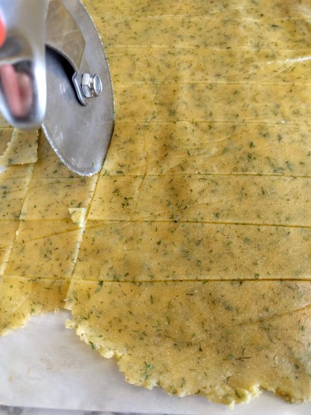 Cutting the cracker dough with a pizza cutter makes cutting them into squares easy.