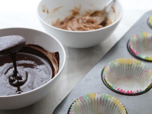 Melted chocolate, almond butter bowl, paper cups - ready to make the almond butter cups