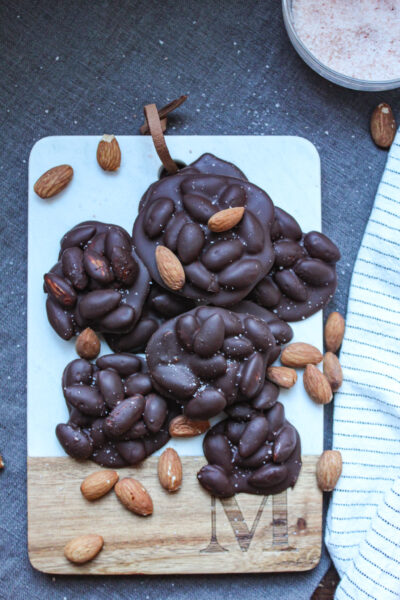 dark chocolate covered almond clusters on cutting board