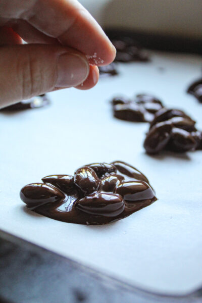 once the chocolate covered almonds are on parchment paper, sprinkle sea salt on them