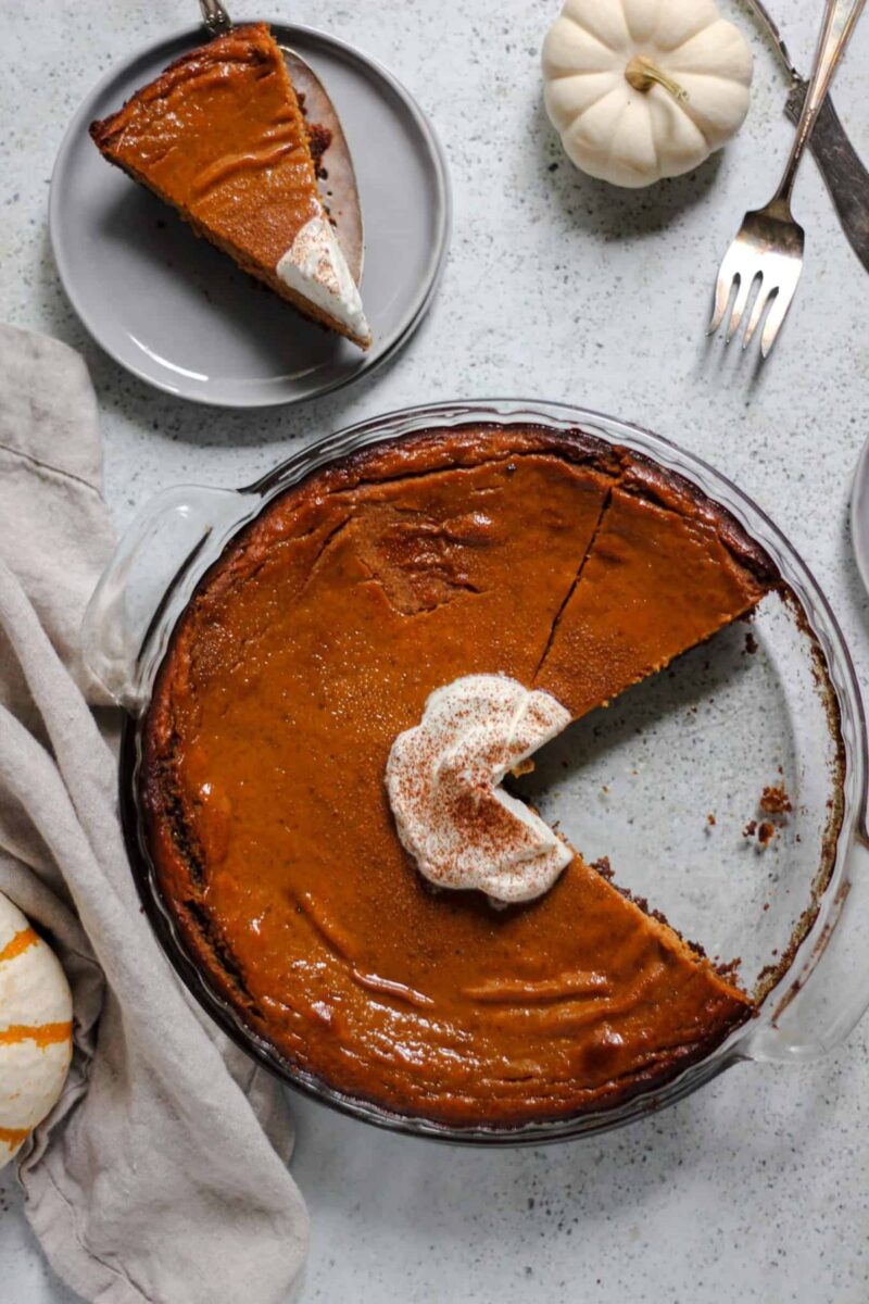 baked and sliced ginger snap cookie crust pumpkin pie topped with cram sprinkled with cinnamon