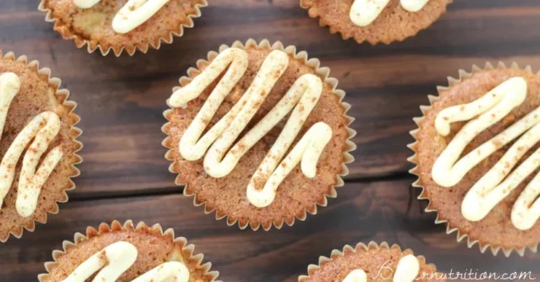baked gluten free apple muffins with buttercream frosting sprinled with cinnamon powder