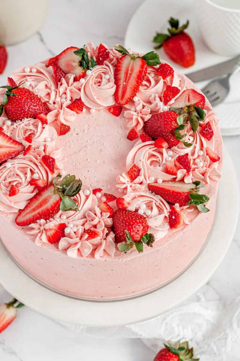 gluten-free strawberry cake with a beautiful design of pink frosting and strawberries