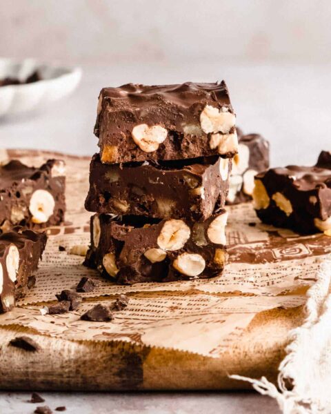 stacked slices of dairy free gluten free rocky road chocolate bars made with nuts, dried fruit and dark chocolate