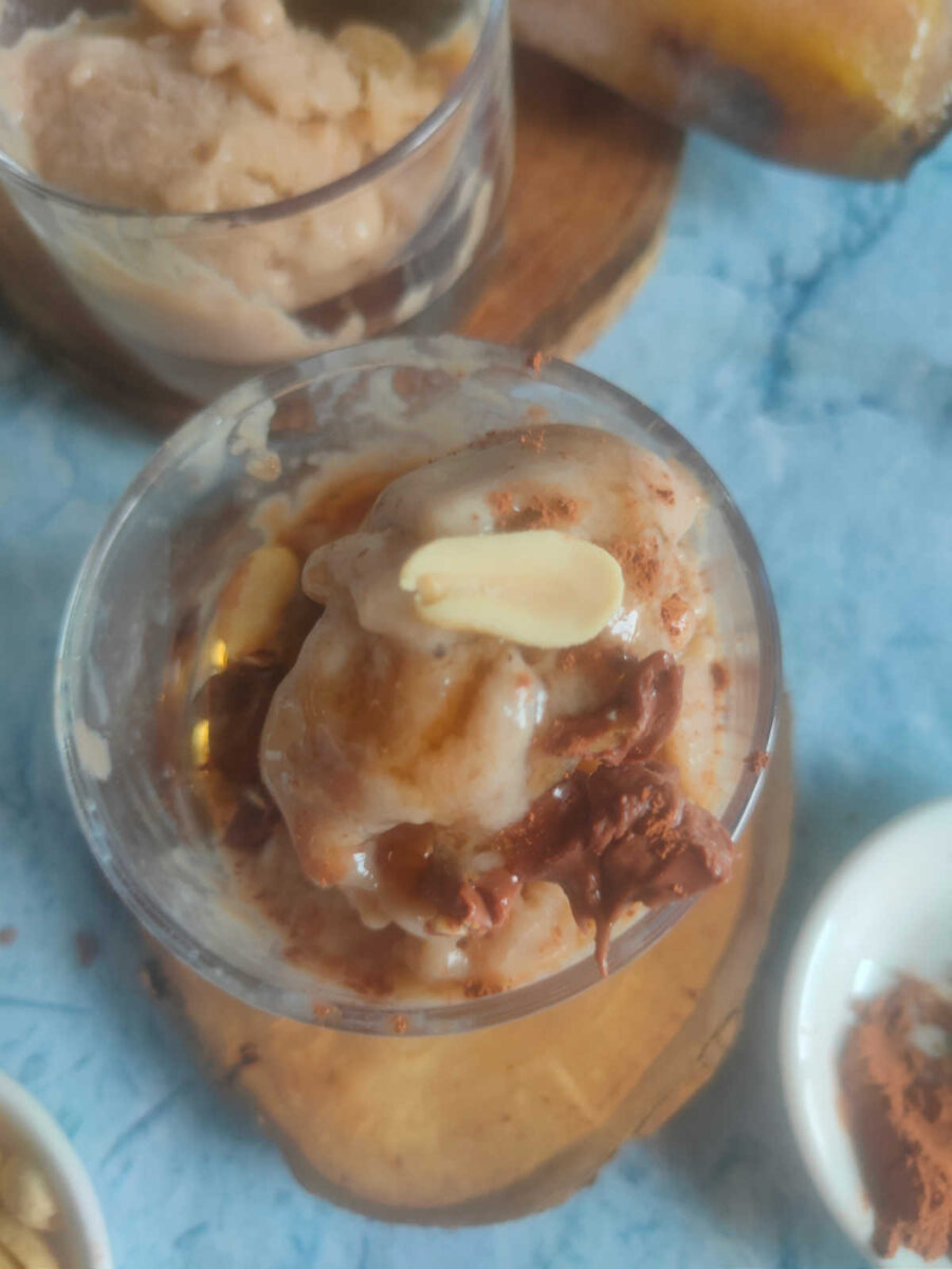 ice cream with chocolate and banana slices in a transparent glass cup